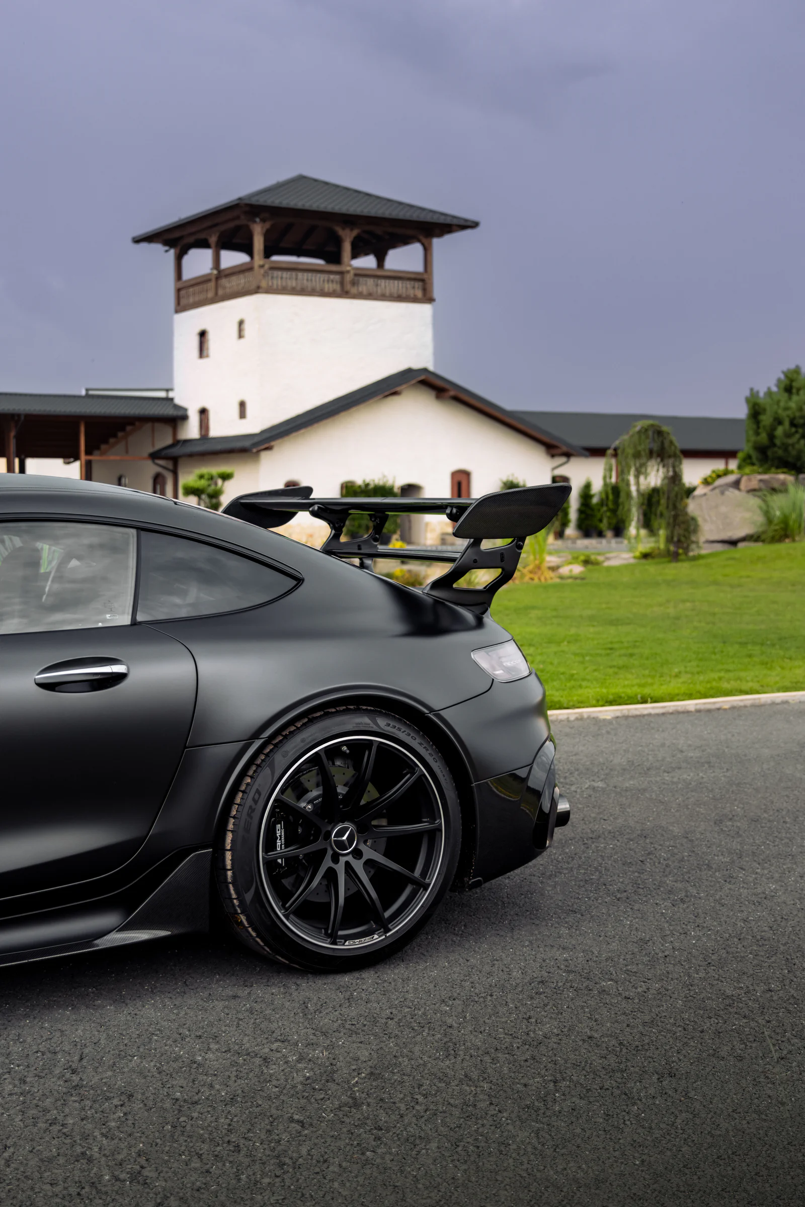 Rear wheel and carbon-fibre wing against the courtyard tower