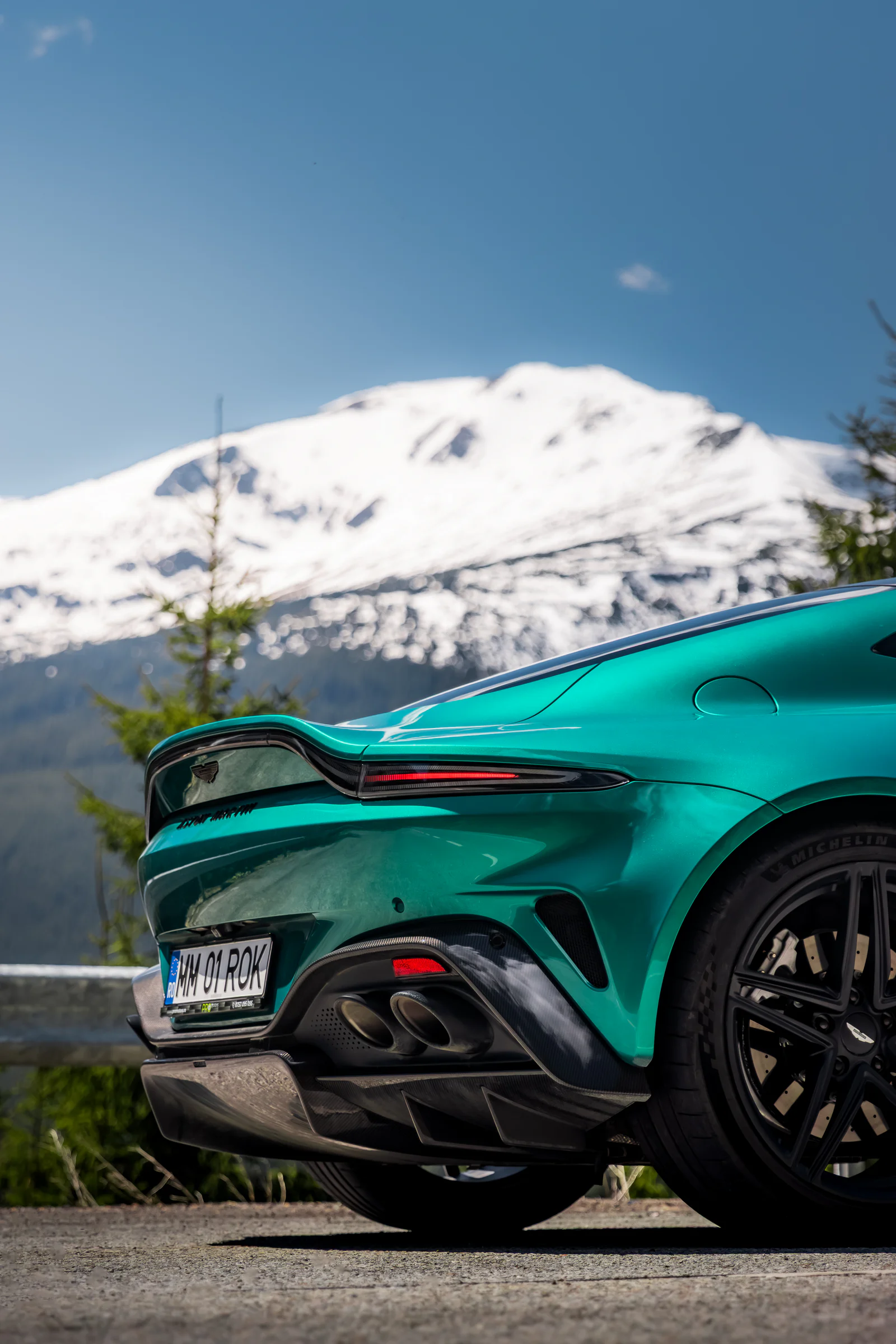 Vantage rear light, wheel and exhaust against a snowy mountain backdrop