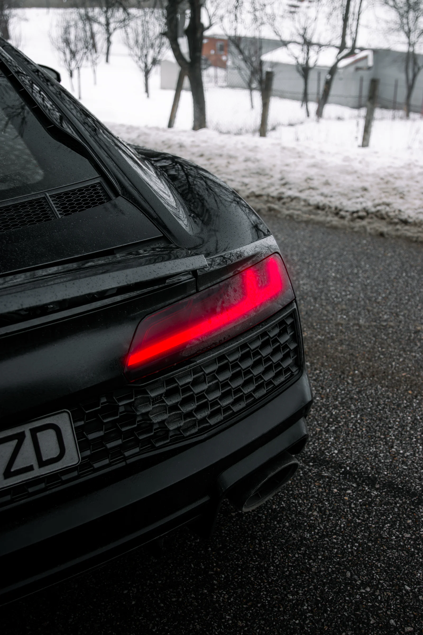 Illuminated rear light against the snow beside the road