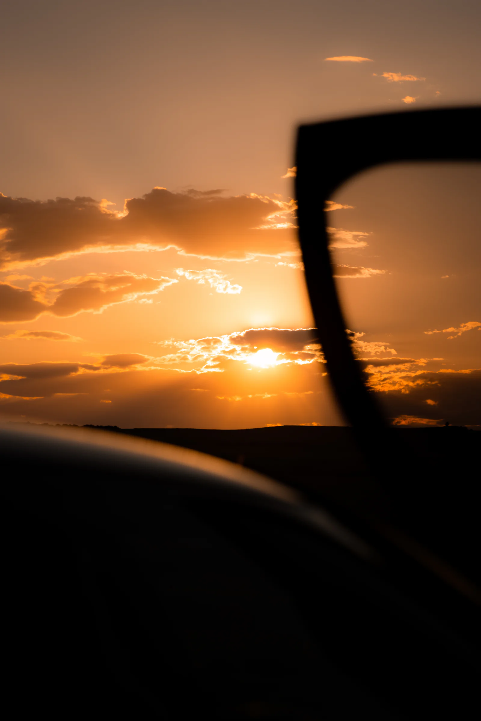 Deep orange sunset framed through the raised BMW i8 door