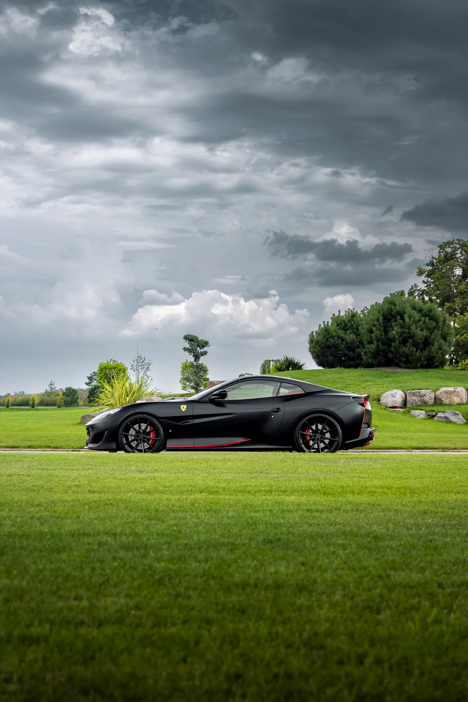 Complete side profile of the matte black Portofino beneath dramatic clouds