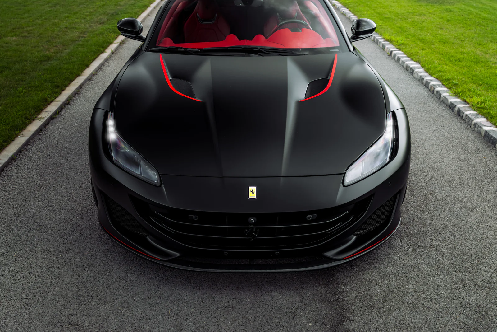 Elevated front view showing the Ferrari bonnet, red accents and red cabin