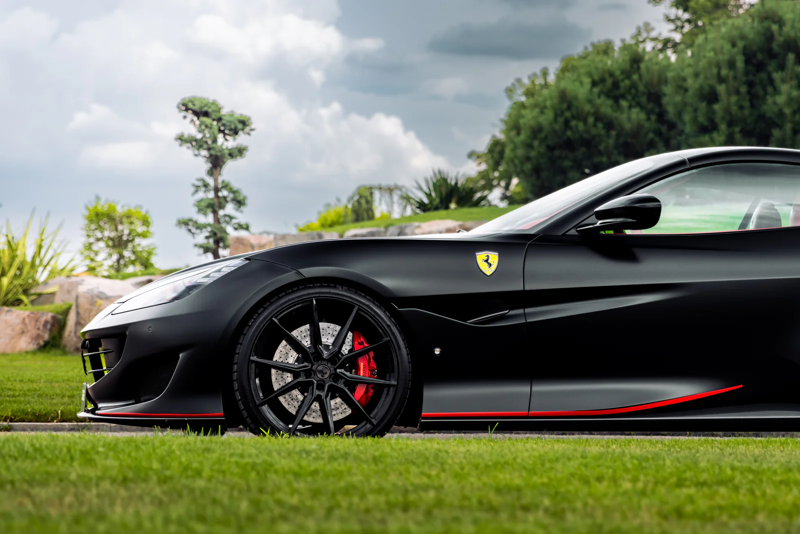 Close side view of the front wheel, Ferrari shield and red side-skirt accent