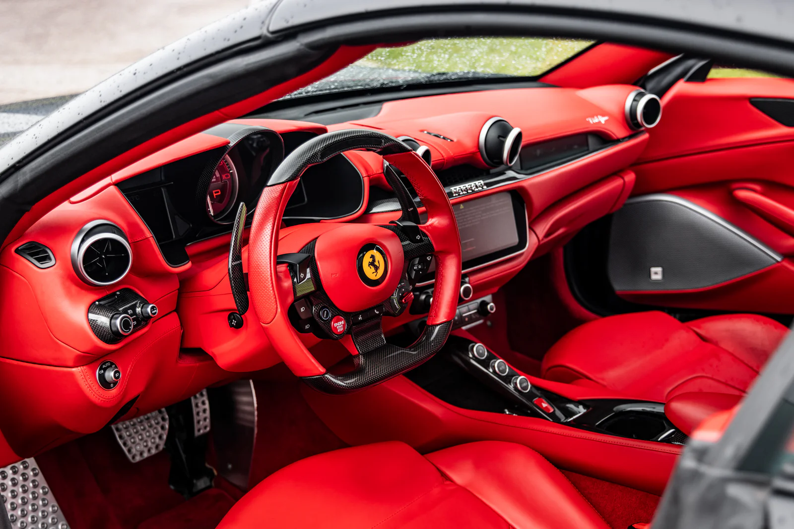 Wide view into the red leather and carbon-fibre Ferrari cockpit