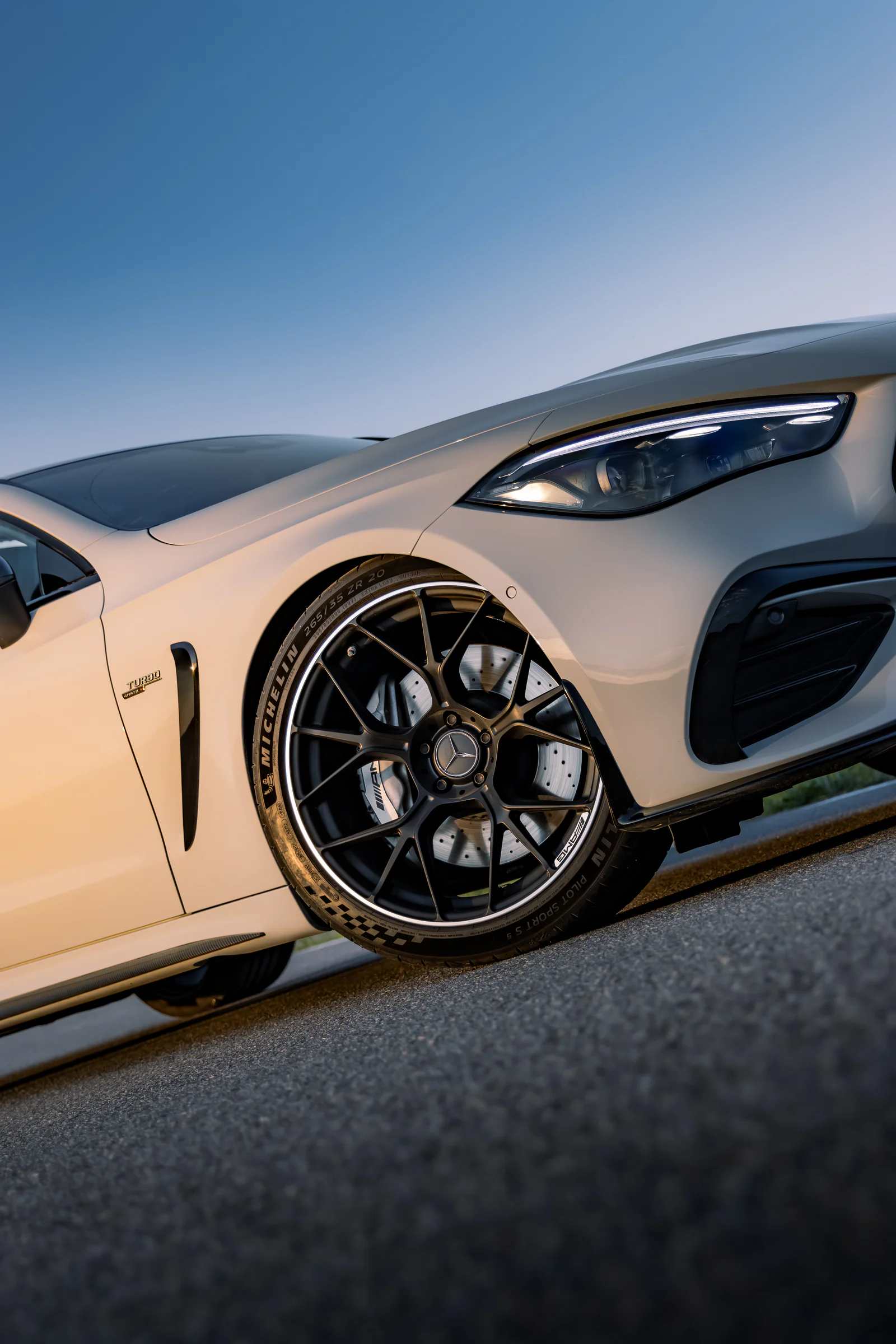 Low diagonal view of the front wheel and headlight in golden light